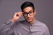 © Jeff B/peopleimages.com - Young man, face and glasses in studio for eye care, vision and new frame with confidence on a gray background. Portrait of a young person or cool model in spectacles, eyewear and vision or lens check
