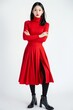 Portrait of a pretty young woman super model of Chinese ethnicity wearing a chic red midi skirt with a slit, paired with a fitted turtleneck top and ankle boots