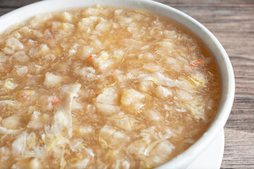 A closeup view of a bowl of crab and fish maw soup.