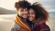 A young interracial couple in love, having fun and embracing on an autumn day at the beach, colors of diversity and love,copy space
