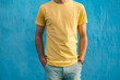 man wearing a yellow T-shirt posing confidently against a vibrant blue background, radiating style and charm, no face