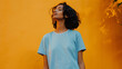 Mock up a woman wearing a blue T-shirt against a vibrant orange background, creating a striking contrast and dynamic visual impact 