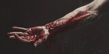 A gruesome image of a bloody hand with blood dripping from it. Perfect for horror or crime scene concepts