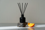Fototapeta Na sufit - Aromatic Reed Diffuser on a Stone Base With Orange Slice Accent
