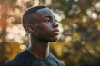 © Uliana - Half-length portrait of young african-american man in sports clothing looking away while standing outdoors