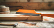 A wooden plank with an orange hand saw on it, construction tools for carpentry work