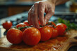 Hand grabbing tomatoes from pile on the table, fresh organic healthy food