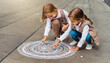 Kinder malen mit Straßenkreide ein Mandala
