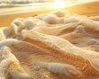 A close-up of a sandy beach textured towel lying on a sunlit golden beach The towel appears to blend seamlessly with the sandy shore