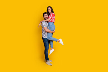 Aufkleber - Full size photo of couple dressed striped t-shirt cuddle together man hold his girlfriend on arms isolated on yellow color background