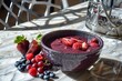 client with acai bowl, fresh berries, steel chairs around