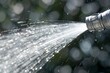 closeup of a garden hose nozzle spraying water