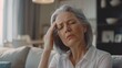 © IgnacioJulian - A middle-aged woman with grey hair and light skin  with headache, pain, sick, illnes