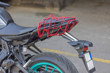 Fototapeta Sawanna - Red Bungee Cargo Net at Sports Motorcycle Seat