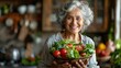 Elderly woman smiling happily and holding a salad bowl of healthy vegetables on a blurred kitchen background 