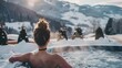 Woman relaxes in hot tub while looking over snow-covered mountains