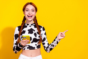 Wall Mural - Photo of toothy excited lady dressed cowskin print top getting sms modern device showing empty space isolated yellow color background