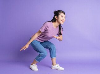 Wall Mural - Photo of young Asian girl on purple background