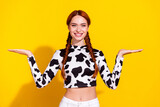 Fototapeta Panele - Photo of excited positive lady dressed cowskin top comparing arms empty space isolated yellow color background