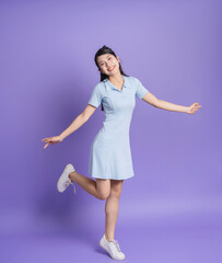 Wall Mural - Photo of young Asian girl on purple background