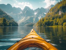 The Front Of A Kayak On A Lake With Forested Mountains In The Background