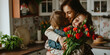 Little children congratulating and hug mother in kitchen with flowers
