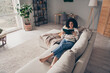 Photo portrait of attractive young woman sit sofa read book dressed casual clothes cozy day light home interior living room