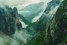 Cinematic Shot Of The View From Above, Looking Down At An Epic Mountain Range With Clouds Rolling Over And Mist Hanging In Between Mountains, Green Grass On Cliffs