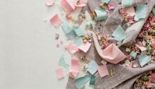 Scraps Of Cloth Fabric From Sewing And Crafting Scattered On A Table, Created A Confetti-like Background Frame.