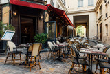 Fototapeta Uliczki - Cozy street near Boulevard San-German with tables of cafe  in Paris, France. Cityscape of Paris. Architecture and landmarks of Paris
