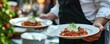 © Filip - Waiter carry plate with steak meat or fresh dish on wedding ceremony.