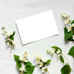 Sticker - Jasmine flowers with blank empty card on light linen background.  Birthday, Mother's Day. Copy space. Creative spring greeting card