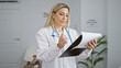 © Krakenimages.com - Young blonde woman doctor writing medical report at clinic waiting room