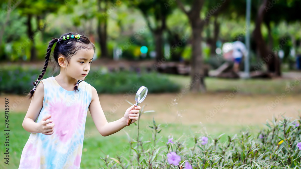 Portrait of asian little girl exploring the nature with magnifying ...
