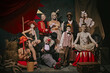 © master1305 - Diverse cast of vintage circus performers poses over dark retro circus backstage background. Promotional poster for upcoming performances. Concept of circus, theater, performance, show, retro and