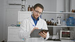 © Krakenimages.com - Young hispanic man scientist writing report standing at laboratory