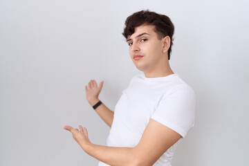 Sticker - Young non binary man wearing casual white t shirt inviting to enter smiling natural with open hand