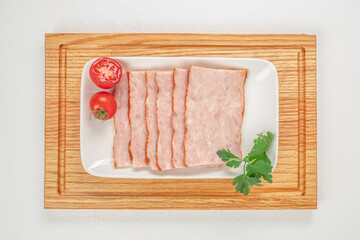 Wall Mural - slices of ham on plate on a white background top view