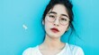 © Abbas - the image of an Asian woman wearing glasses, posing confidently against a vibrant white background.