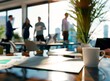 © zayatssv - Close up of an office desk with papers, a laptop and a coffee cup on it. In the background, business people are having a blurred conversation in an out-of-focus style. Bokeh.