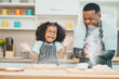 © chokniti - In a home kitchen, black father and his daughter bond over cooking a meal food, their laughter and love filling the air, embodying the joy of African American family life, Father's Day concept