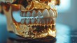 Close-up of a human skull replica with a jaw coated in polished gold, creating a stark contrast against a dark background