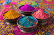 Cuencos metálicos conteniendo polvos de colores para fiesta holi india, sobre fondo colorido decorado con dibujos étnicos y polvo holi 