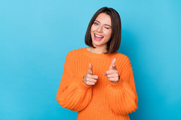 Wall Mural - Portrait of attractive flirty funny cheerful girl winking pointing forefingers at you isolated over vibrant blue color background