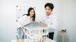 Closeup of young professional skilled architect engineer team focusing on checking the house model structure at modern office. Creative professional design and teamwork concept. Immaculate.
