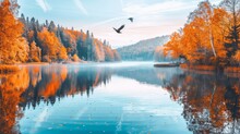 A Bird Flying Over A Body Of Water Surrounded By A Forest Filled With Orange And Yellow Trees In The Fall.