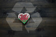 © luzitanija - wooden heart with national flag of wales near reduce, reuse and recycle sing on the wooden background. concept