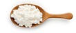 Wooden spoon with cottage cheese on white surface