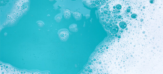 Wall Mural - Detergent foam bubble on water. Blue background, Soap sud