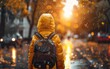 Child walking to school along a busy urban street on a rainy autumn morning at dawn